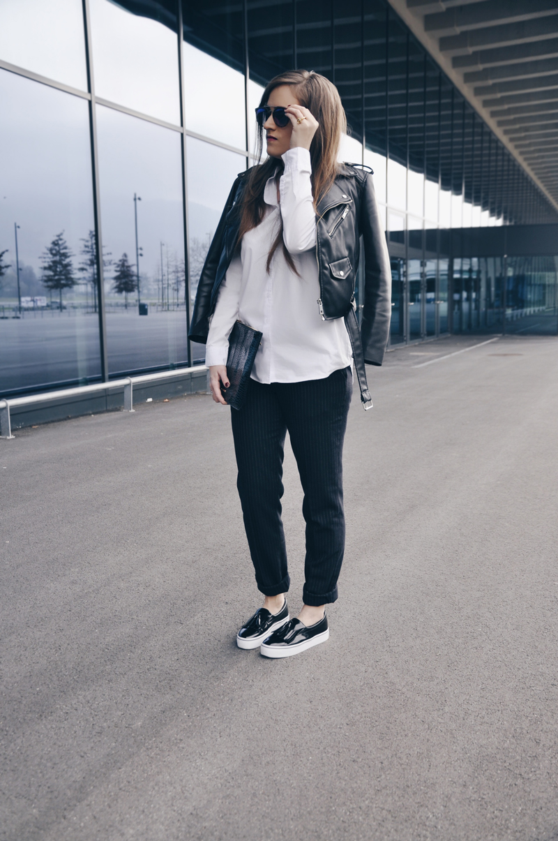 Nadelstreifen Hosen von Uniqlo dazu eine weisse Oversize Bluse von Asos und eine Lederjacke von Zara. Die Schuhe Sind von Bershka und die schwarze Lacktasche von Zalando.