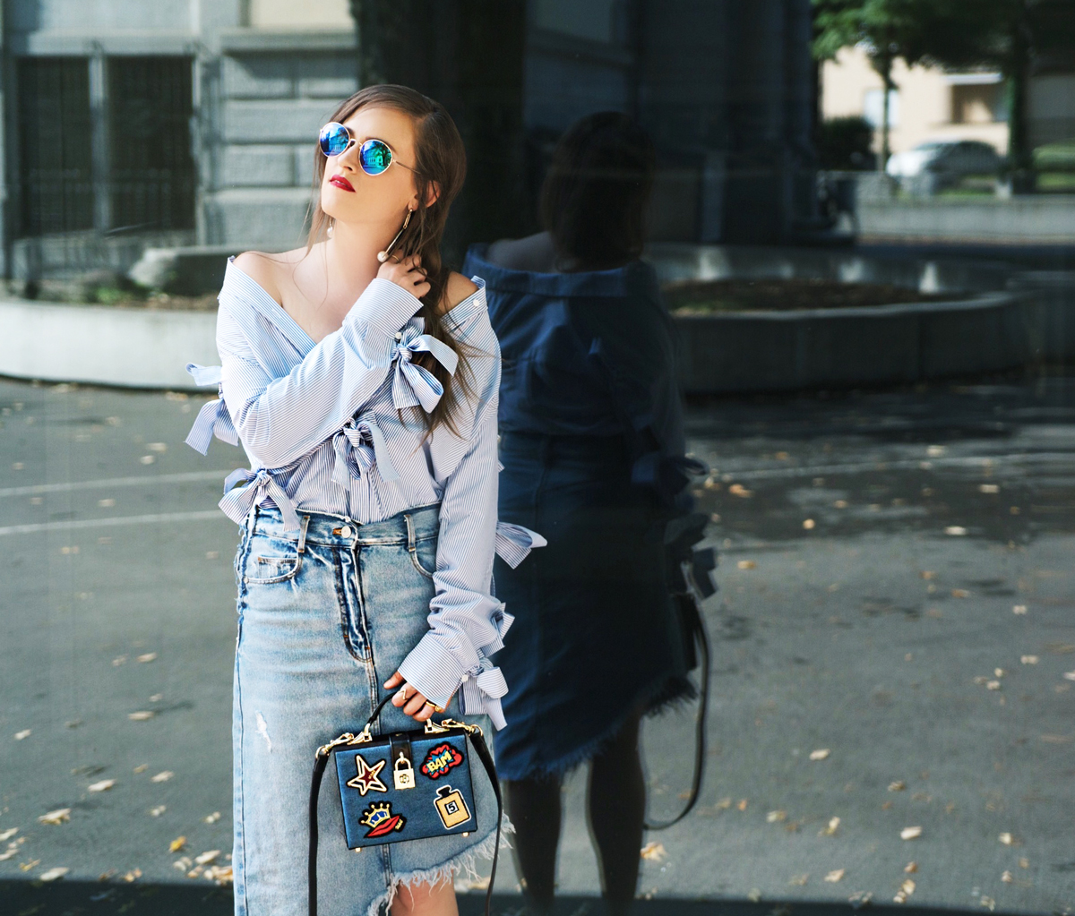 Fashionblogger Andrea Steiner von Strawberries 'n' Champagne trägt einen knielangen Jeansrock von Zara, dazu eine gestreifte Bluse mit Maschen an den Ärmeln von H&M. Die Tasche is Handmade von Shanghai und die Schuhe ebenfalls Handmade von Hong Kong. Das Make up ist Mac Cosmetics und die Sonnenbrille von H&M.
