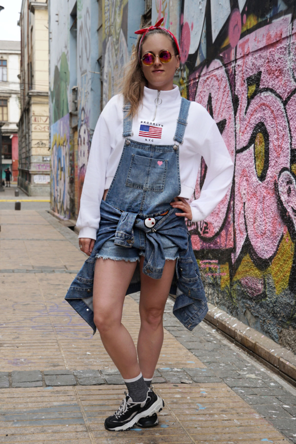 Denim dungarees trend with a sweater and sneakers