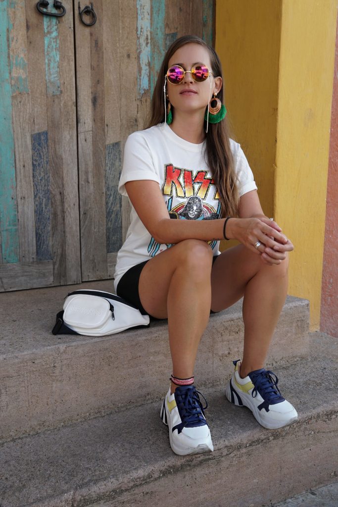 Andrea Steiner vom Mode Blog Strawberries 'n' Champagne aus der Schweiz trägt schwarze kurze Leggings mit einem Band Shirt von Kiss, plateau Sneakers und eine kartiertes Hemd.