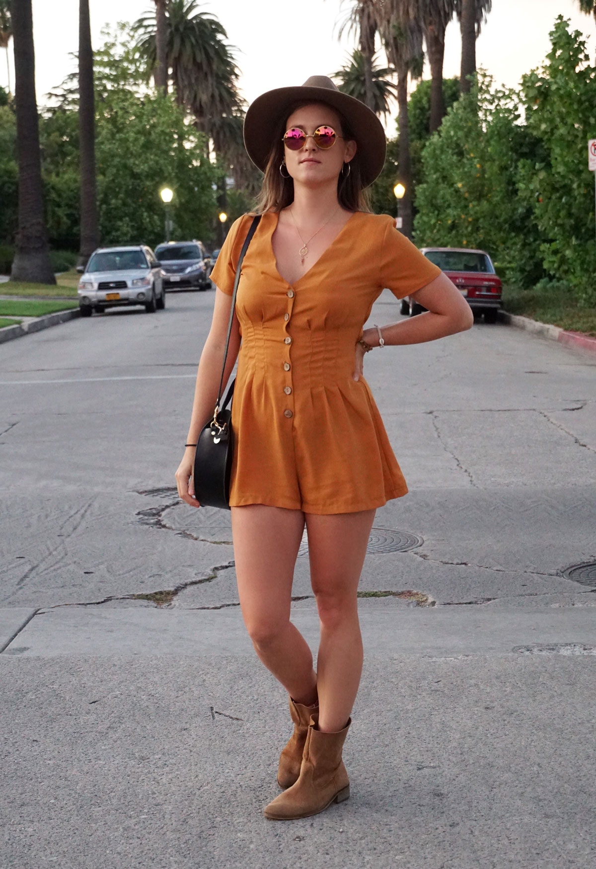 Andrea Steiner vom Mode Blog Strawberries 'n' Champagne aus der Schweiz trägt einen Jumpsuit, Boots, Tasche und einen selbst kreierten Hut.