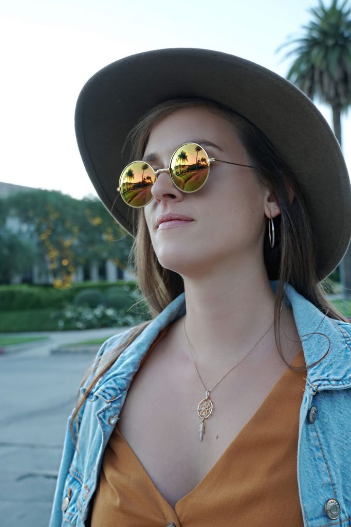 Andrea Steiner, fashion blogger from Strawberries 'n' Champagne based in Switzerland is wearing a romper with a jeans jacket, boots, bag and a self made hat