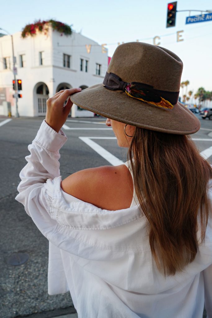 Andrea Steiner, fashion blogger from Strawberries 'n' Champagne based in Switzerland wears black mom jeans with a white cropped top and a oversize blouse.