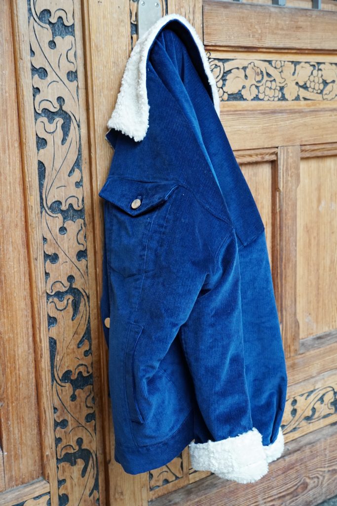 Andrea Steiner vom Mode Blog Strawberries 'n' Champagne aus der Schweiz trägt vegane und nachhaltige Mode. Einen blauen Anzug von SANIKAI, dazu einen gelben Pullover von JAN N JUNE und weisse Turnschuhe von EKIN.