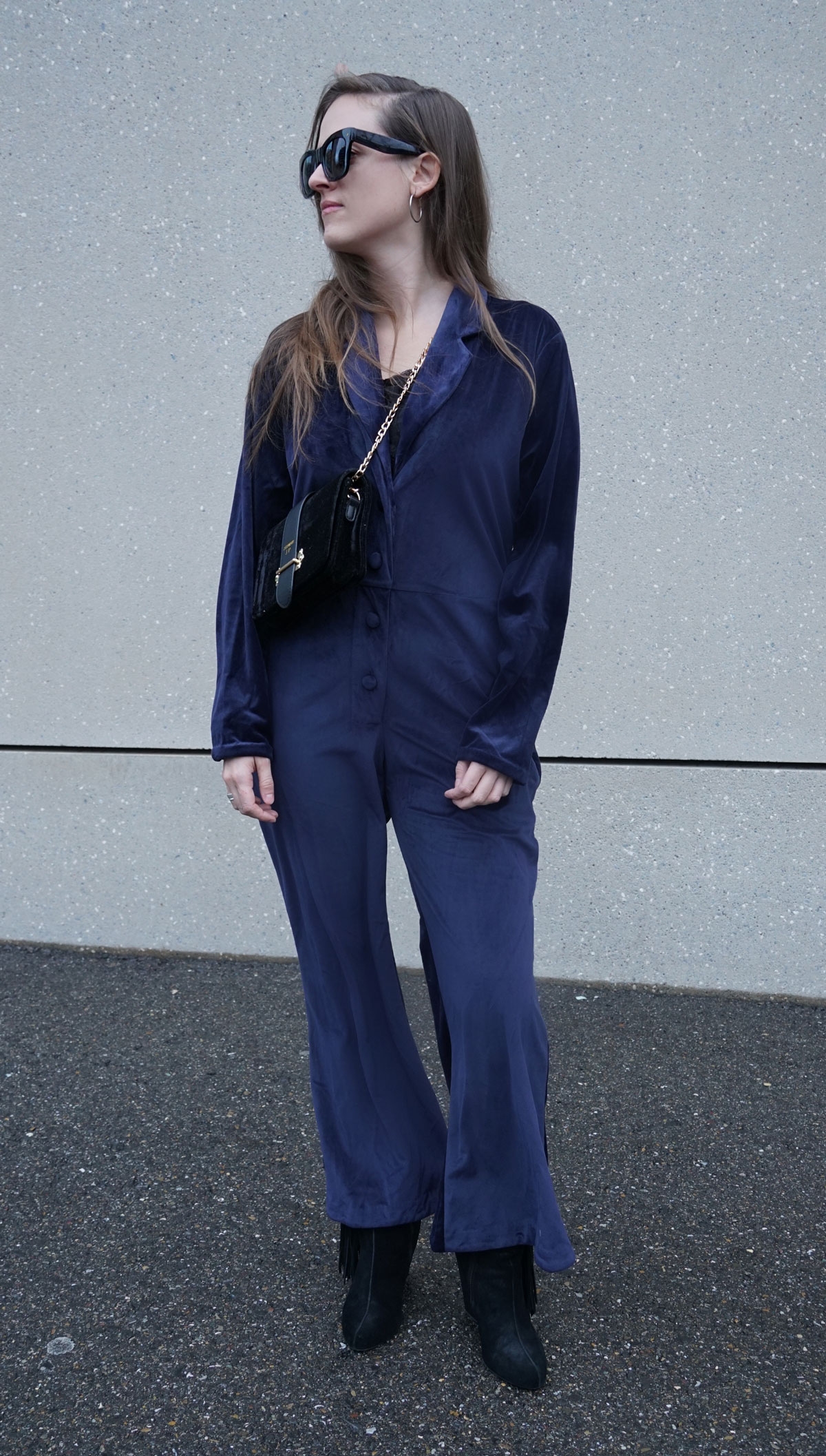 Andrea Steiner vom Mode Blog Strawberries 'n' Champagne aus der Schweiz trägt für die Festtage einen dunkelblauen Jumpsuit aus Samt.