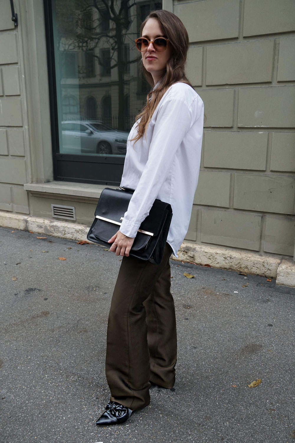 Andrea Steiner vom nachhaltigen Mode Blog Strawberries 'n' Champagne aus der Schweiz trägt eine Burberry Hose die sie von ShareaLook gemietet hat, kombiniert mit einer weissen Bluse, schwarzen flachen Schuhen und einer schwarzen Tasche.